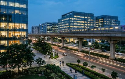 Lit office towers and an elevated metro line in the New Town business district of Kolkata at blue hour